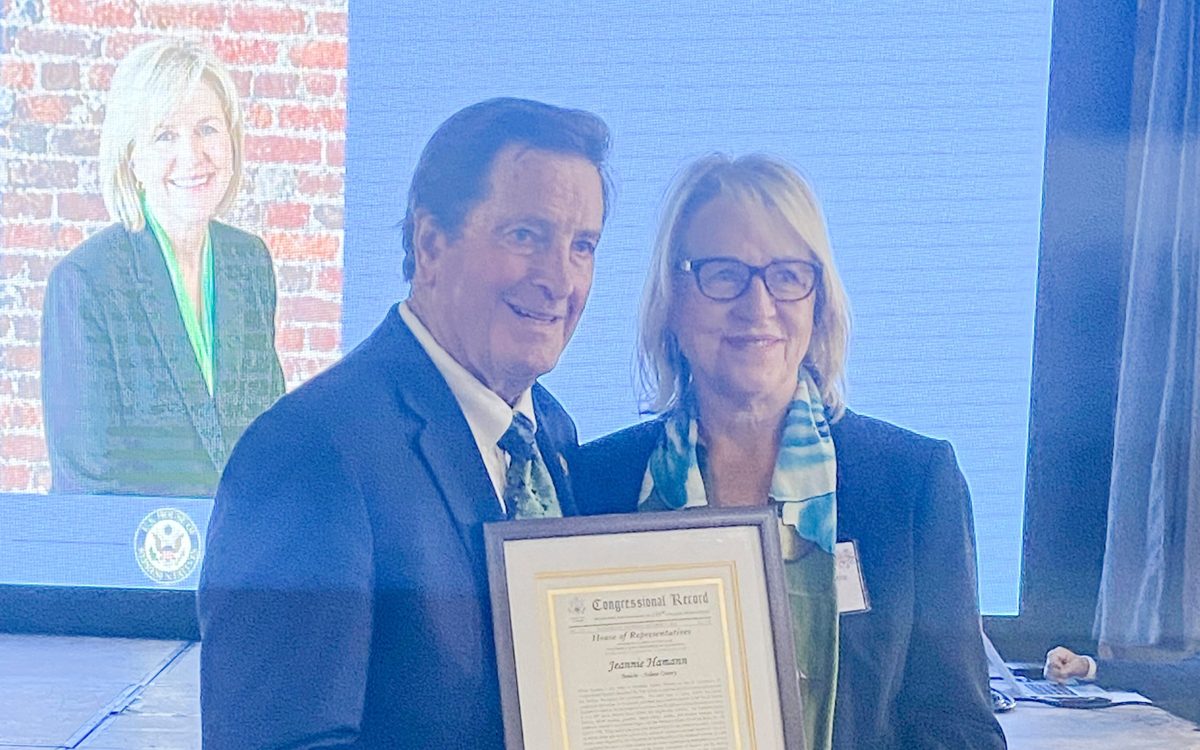 Congressman John Garamendi and Jeannie Hamann holding her 2026 Woman of the Year Congressional Record